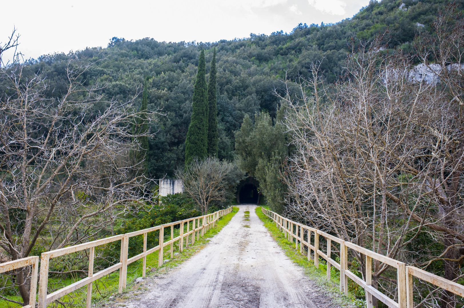 Strada sterrata che entra nella valle verso una galleria scavata nella roccia